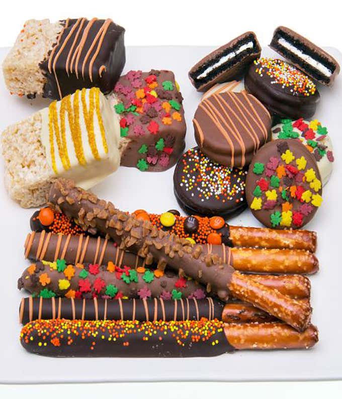 A delicious assortment featuring chocolate-covered rice treats, chocolate-covered OREO® cookies, and chocolate-covered pretzels, all adorned with fall-themed edible decorations and coated in dark, white, and milk chocolate.
