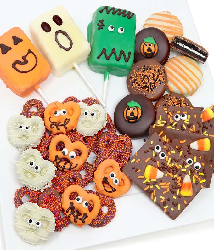 6 chocolate dipped OREO® Cookies with Halloween designs, Chocolate bark with candy corn and yellow, orange, and brown sprinkles, 6 chocolate dipped pretzels (3 orange with eye sprinkles & 3 white with eye sprinkles), and 3 chocolate dipped crispy rice pop