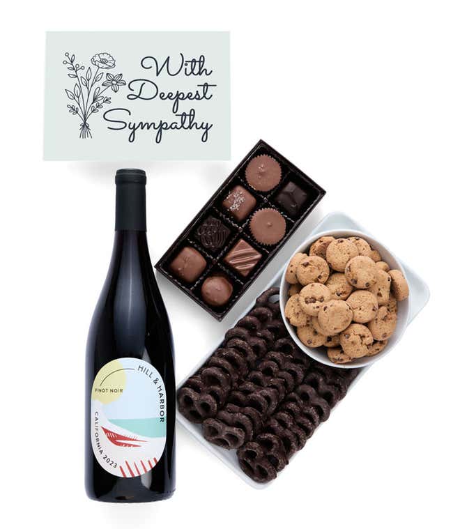 A gift box with chocolate pretzels, chocolate graham crackers, red velvet cookies, hazelnut wafer rolls, an 8 piece box of chocolates, a bottle of red wine and a Sympathy message card.