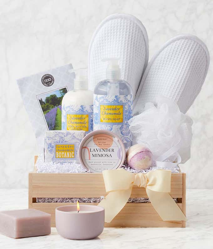 Lavender spa gift crate with waffle slippers, loofah, lavender & thyme candle, lavender bath bomb, lavender chamomile hand soap, lotion, bar soap, and scented sachet