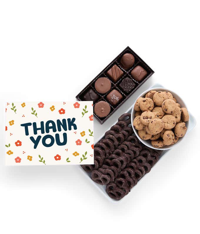 A gift box with chocolate pretzels, chocolate graham crackers, red velvet cookies, hazelnut wafer rolls, an 8 piece box of chocolates and a Thank You message card.