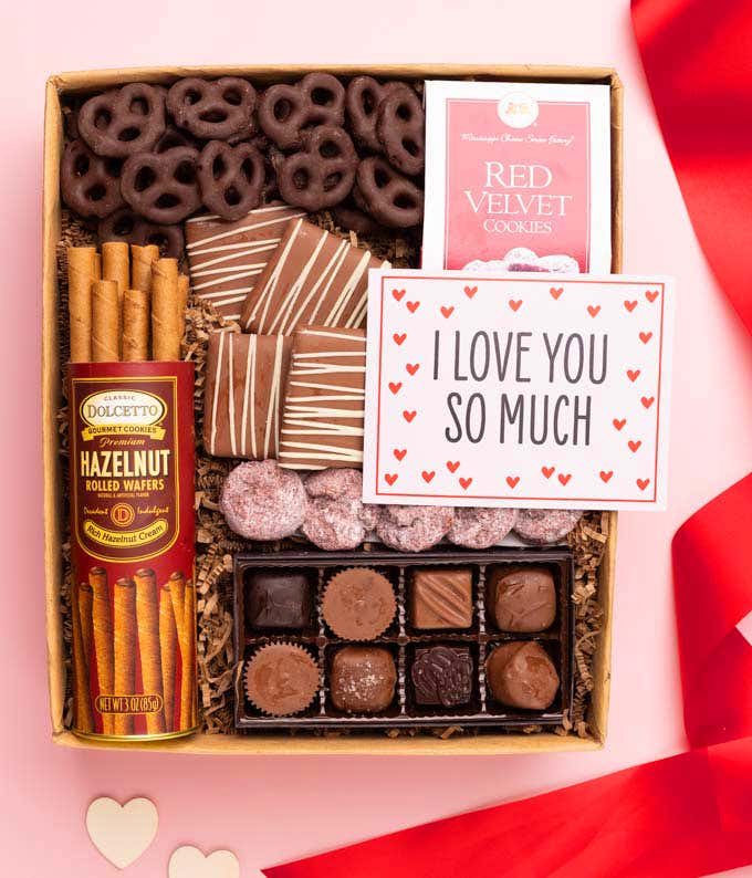 A gift box with chocolate pretzels, chocolate graham crackers, red velvet cookies, hazelnut wafer rolls, an 8 piece box of chocolates and an I Love You message card.