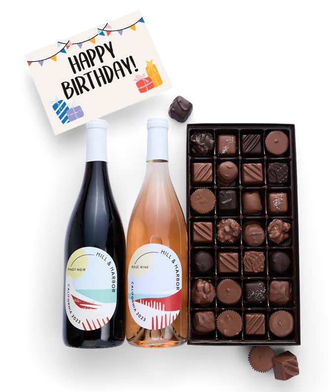 A gift box containing two bottles of California Wine - Pinot Noir & Rosé wine, a 1 lb box of 28 assorted gourmet chocolates in a grid, and a birthday message card.   A refined combination perfect for birthday celebrations.